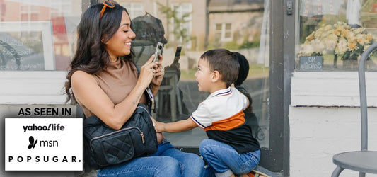 Mom wearing the Jetsetter Mini Diaper Bag on a park outing, showing the compact size and hands-free design editors love.
